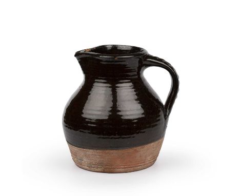 Michael Cardew (1901-1983) An early jugslipware with treacle glazeimpressed potter's seal21cm high.Overall wear and marks as 