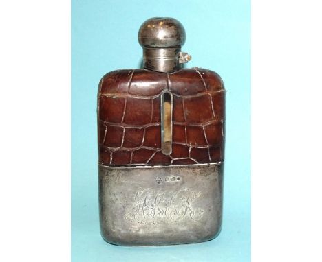 An Edwardian silver hip flask with a glass moulded body and 'crocodile skin' leather top, the detachable cup with etched init