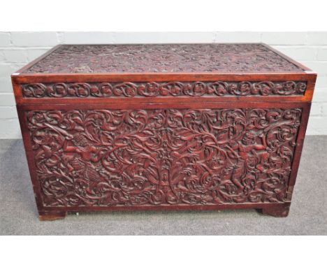 A 19th century Indian teak rectangular lift top trunk with profusely carved decoration, 91cm wide x 55cm high. 