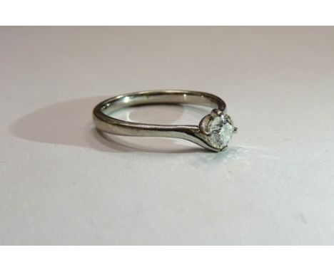 A platinum and diamond single stone ring, claw set with a circular cut diamond in a twistover design, ring size K.