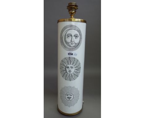 A Fornasetti table lamp decorated with sun motifs against a cylindrical white metal and gilt body, 51.5cm high excluding fitm