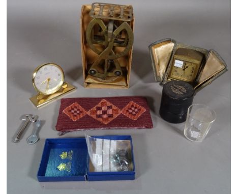 A Zenith travelling alarm clock, with a folding case, a Looping alarm clock, a brass set of letter scales and a medicine glas