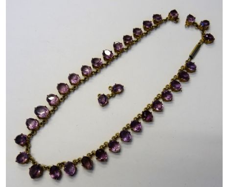 An amethyst necklace, formed as a row of graduated oval cut amethysts, on a cylindrical clasp, (two amethyst links detached, 