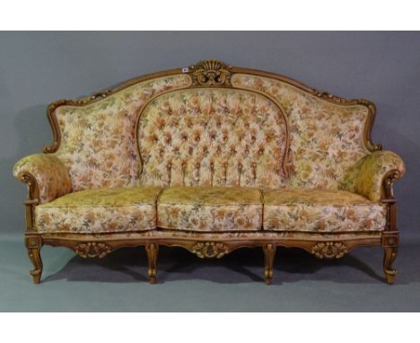 A 20th century hardwood framed three seater sofa with roll-over arms, button back gold floral upholstery on scroll supports, 