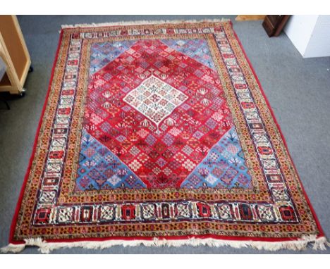 A Joshaghan carpet, Persian, the madder field with an ivory diamond, matching indigo spandrels, all with diamond flower burst