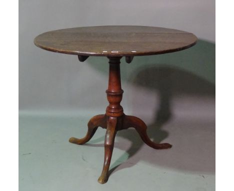 A George III oak circular tilt top tripod table, on outswept supports, 87cm wide x 70cm high.