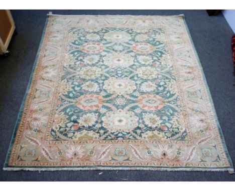 A modern Egyptian carpet, the sage field with an overall bold floral design, a beige palmette and leaf border, 290cm x 258cm.