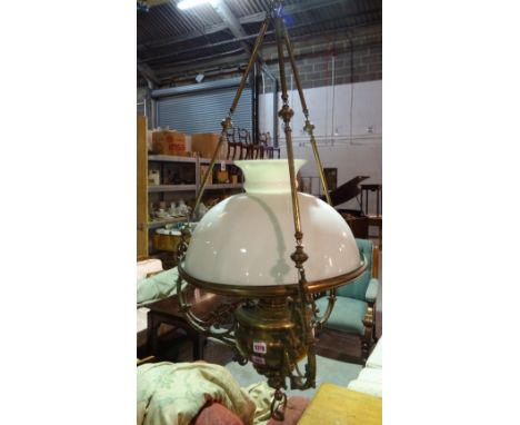 A Victorian style gilt metal hanging oil lamp (converted to electricity), the circular foliate cast body and opaque glass sha