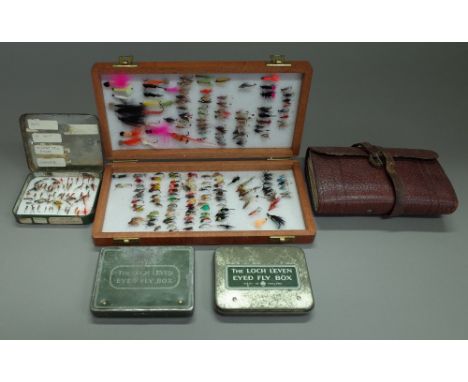 A Richard Wheatley wooden fly box with aprox 160 flies, three Wheatley 'Loch Leven eyes' fly boxes and an Army &amp; Navy lea