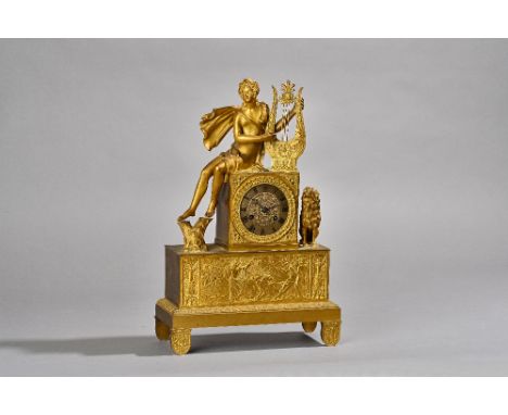 A French Empire style gilt metal figural mantel clock, 19th century, the Classical female figure playing a harp with lion ben