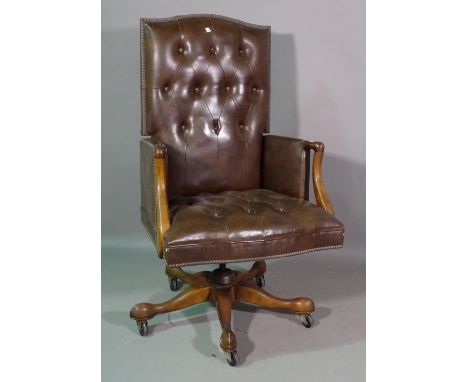 A 20th century mahogany framed button back brown leather office armchair. 