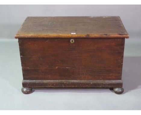 An early 20th century stained pine lift top trunk on bun feet, 88cm wide x 54cm high. 