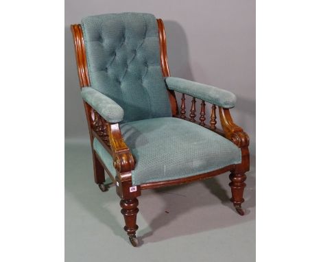 A Victorian mahogany framed low armchair with button back upholstery on ring turned supports. 