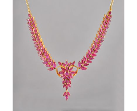 A gold and ruby necklace, the front with a central foliate cluster, between tapered foliate sides, mounted with pear shaped r