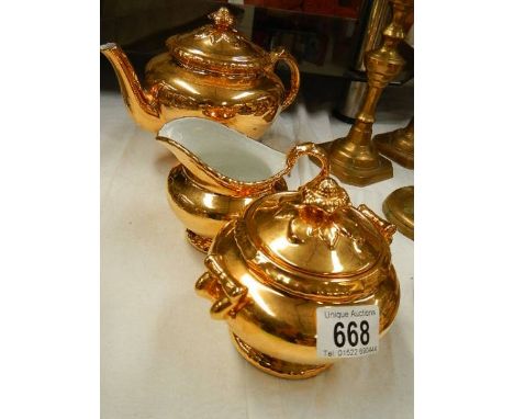 A three piece Royal Worcester gilded tea set.