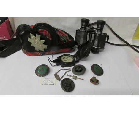 A Scottish military cap, field glasses, compass, German and other badges.