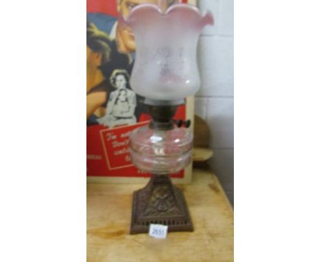 A Victorian oil lamp on cast iron base with glass font, original Duplex burner and later glass shade.