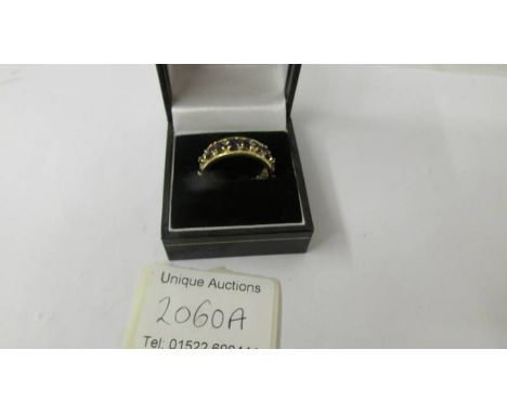 An 18ct gold band ring set sapphires and small diamonds, size R. 6.9 grams.