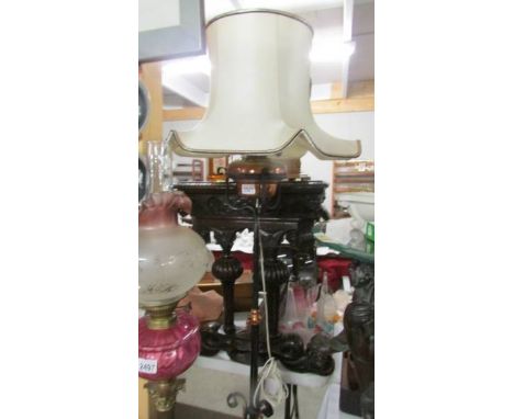 A wrought iron standard lamp with copper font, converted to electric.