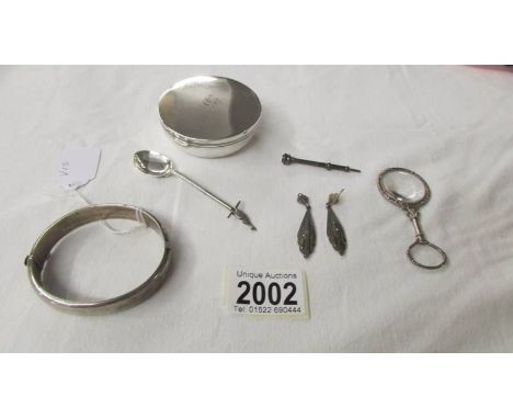 A hall marked silver bangle, a silver spoon, a pair of silver marcasite earrings, an  unmarked lidded pot, silver plate magni