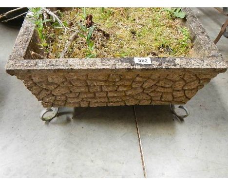 A good old square garden planter on metal feet.