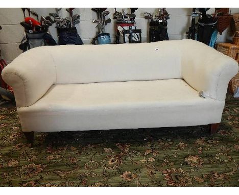 A chesterfield sofa covered ready for upholstery, caster needs repair.