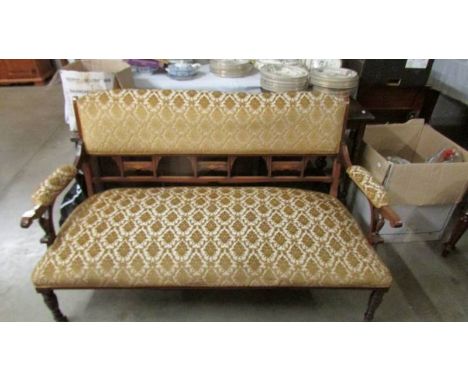 A mahogany framed sofa on casters.