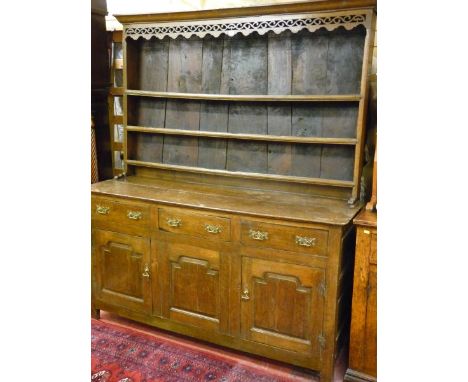 A LATE 18TH CENTURY OAK WELSH DRESSER, the three shelf rack with decorative fretwork apron and wide boarded closed back over 