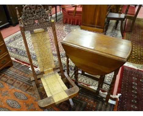 AN OAK BARLEY TWIST GATE LEG TABLE and a Balinese style carved and seagrass seated folding chair