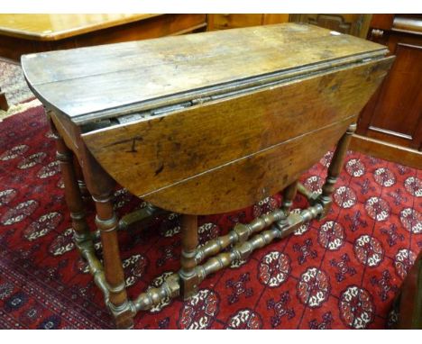 AN 18TH CENTURY AND LATER OAK GATE LEG TABLE with single end drawer front (drawer lining missing) on peg jointed turned and b