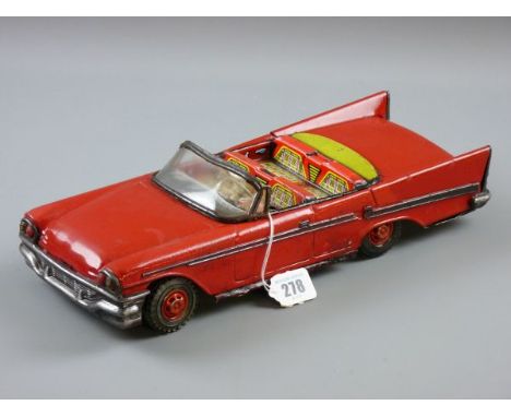 A MID CENTURY AND LATER TINPLATE OPEN TOP CADILLAC friction drive action in red livery with lithograph seats and dashboard, t
