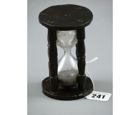 A TREEN EGG TIMER, an early example having four simply turned pillars with early glass sand receptacles, height 10 cms, diame