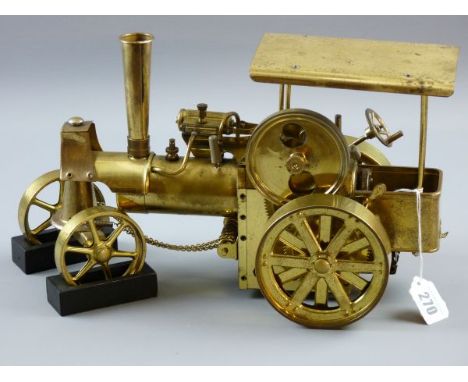 A BRASS MODEL TRACTION ENGINE STEAM TRAIN, steered model with front wheel chocks, marked to the base 'Made in Western Germany