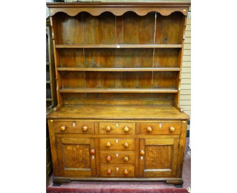 AN EARLY 19TH CENTURY ANGLESEY OAK DRESSER, the three shelf shape sided rack with decorative top apron and wide back boards o