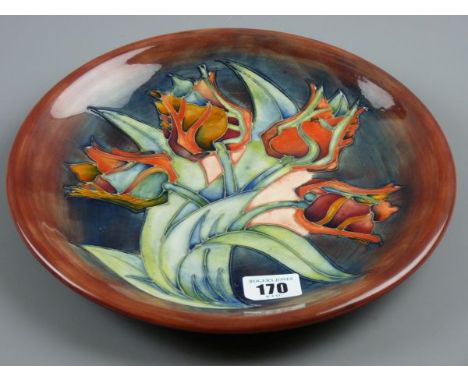 A MOORCROFT TULIP PLATE, a 26 cms diameter plate decorated on a tonal blue brown ground, impressed 'Moorcroft, Made in Englan