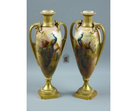 A PAIR OF ROYAL WORCESTER TWIN HANDLED VASES, decorated with opposing hand painted peacocks and hens upon pine branches, poss