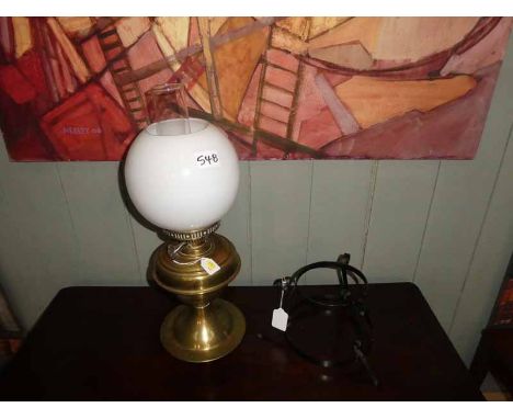 A brass parafin lamp converted to electricity, and a wrought iron stand