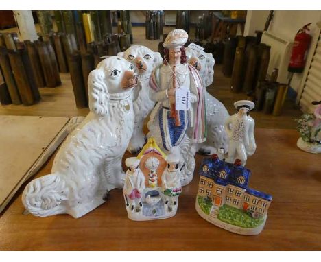 A group of Staffordshire flatback figures including: theree 1920s chimney dogs, a piper with cloak, a clocktower group, man w
