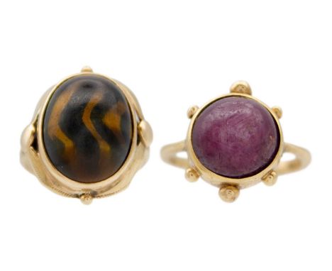 A 9ct hallmarked gold cabochon ruby set ring and a 9ct tiger's eye set ring. The ruby ring hallmarked London 1963, size K, th