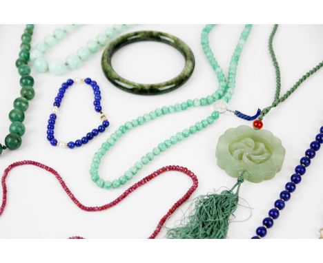 A selection of jadeite and hard-stone jewellery. To include a circular bangle, a graduated dark green jadeite necklace with g