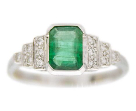 A modern Art Deco style 9ct white gold emerald & diamond set dress ring. The emerald cut emerald of 0.68ct estimated weight, 