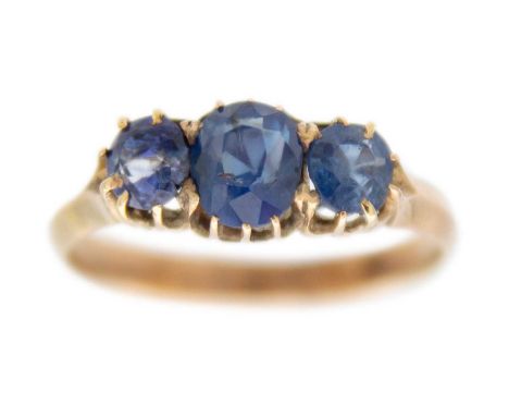 A 9ct rose gold blue sapphire set three-stone ring. The sapphires oval cut, unmarked, size K, 2.2g.
