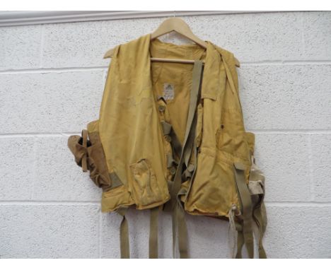 yellow drill material vest.  Tan canvas light pocket to the right side.  Left chest mirror pocket.  Rear cream rip open pocke