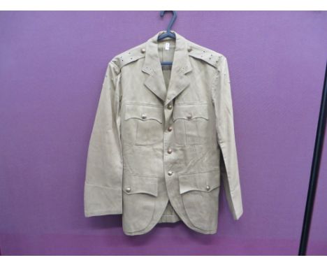 light khaki drill, single breasted, open collar doublet.  Pleated breast and lower bag pockets, all with buttoned flaps.  Bra