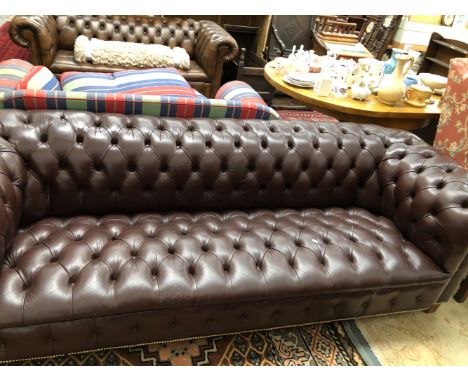 A BROWN LEATHER BUTTON UPHOLSTERED CHESTERFIELD SETTEE.   W 235cms.