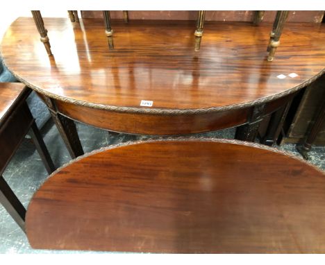 A 19th C. MAHOGANY DEMILUNE TABLE OPENING ON A GATE LEG WITH CARVED EDGE ABOVE TAPERING SQUARE LEGS CARVED WITH GARRYA HUSKS.