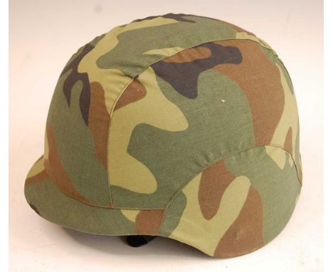 A Chinese Peoples Liberation Army composite helmet, having a leather liner, canvas chin strap and camouflage outer cover.