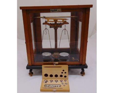 A set of brass weighing scales in glazed mahogany case with additional cased weights, 42cm (h) 37cm (w) 27cm (d)