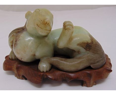 A jade figurine of a lion on original hardwood stand, 20cm (w)