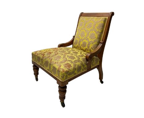 Late Victorian oak nursing chair, moulded frame with flower head carved roundels, upholstered in floral pattern fabric, on tu